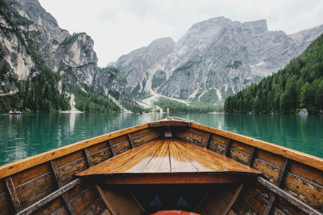 Barca di legno sull'acqua verde del Lago di Braies con la Croda del Becco sullo sfondo, Dolomiti