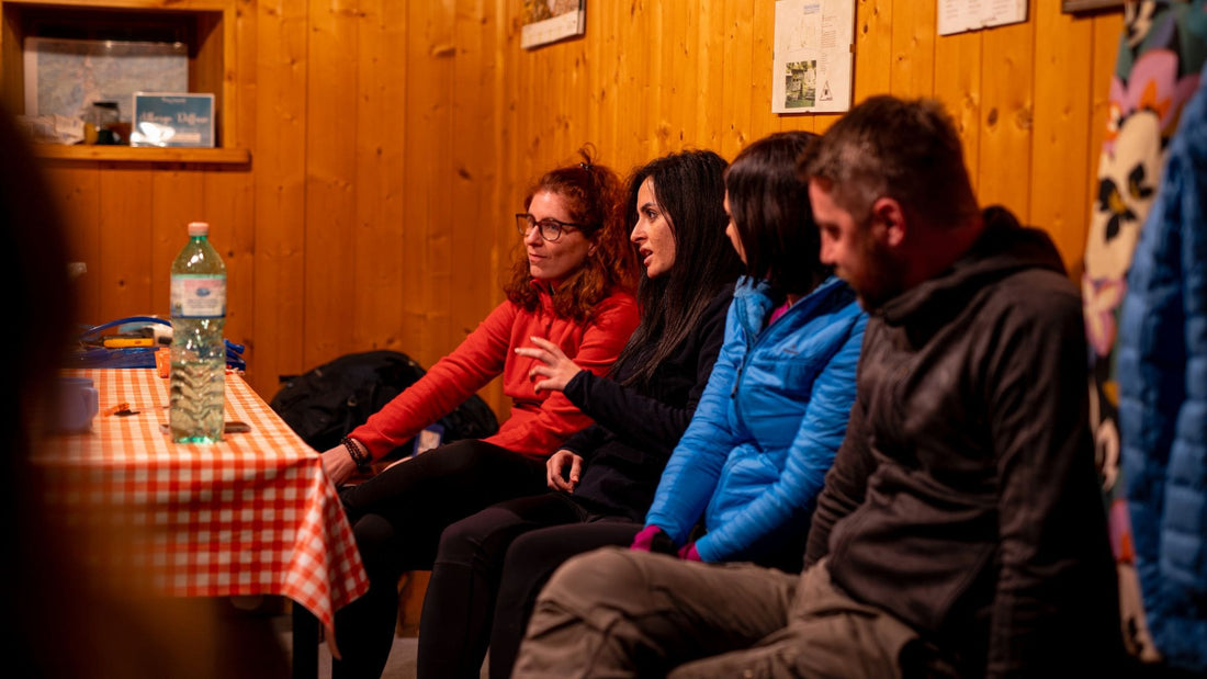 Un team aziendale percorre insieme un sentiero panoramico tra le montagne delle Dolomiti, collaborando e rafforzando la fiducia durante un’esperienza di team building nella natura.