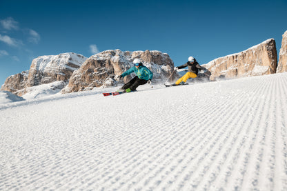 Sciatore su una pista soleggiata dell'Alta Badia con le Dolomiti sullo sfondo