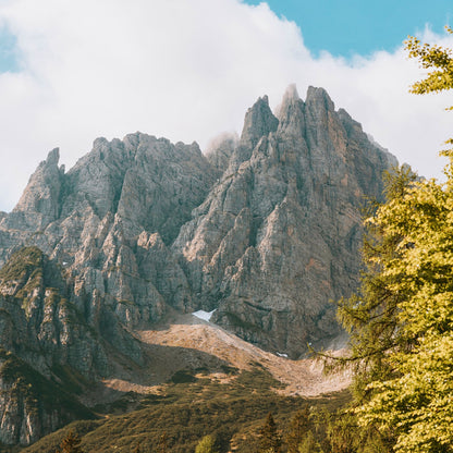 Dramatic jagged limestone ridge with clouds swirling around Cima dei Preti peak in Dolomiti Friulane