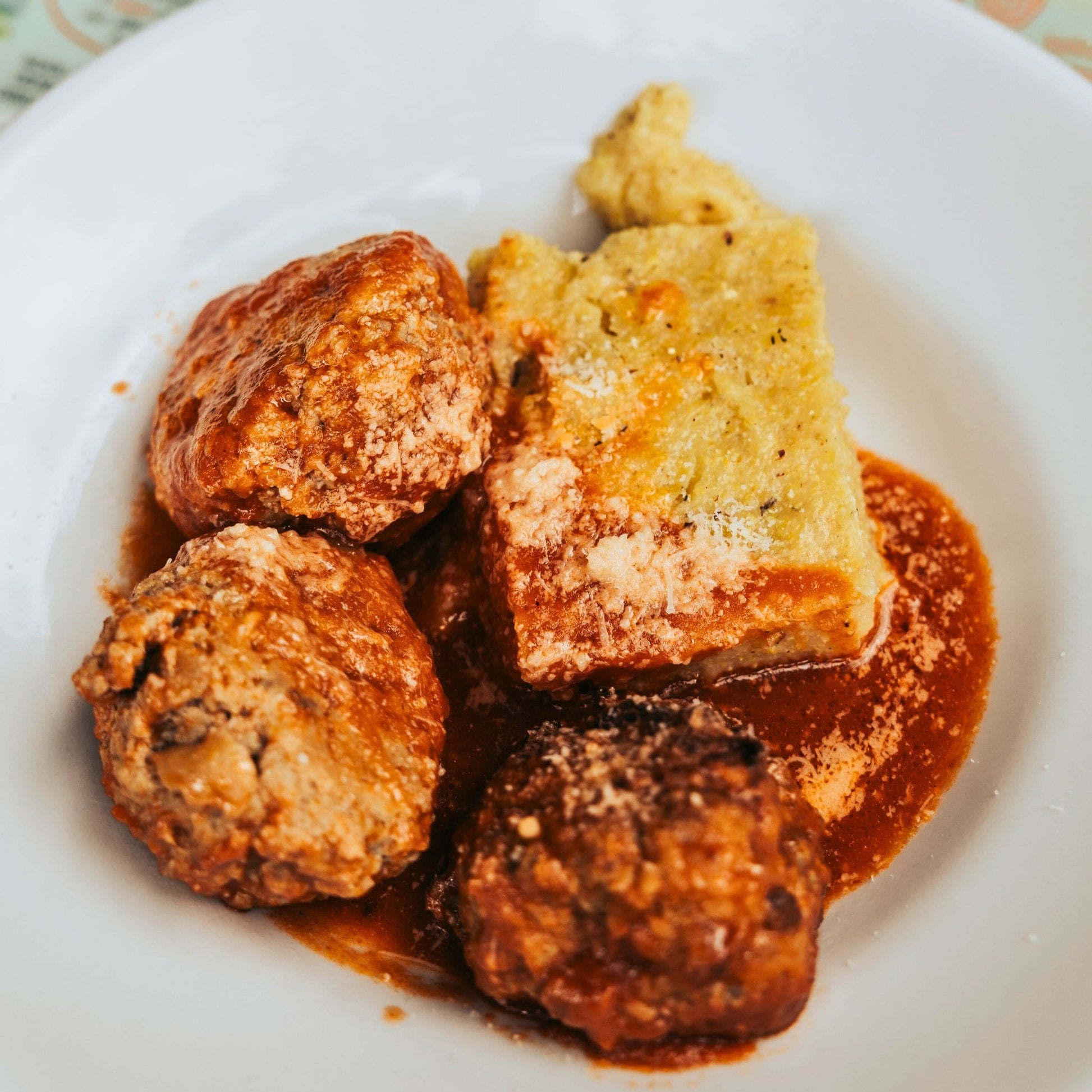 Traditional Friulian polenta with meat sauce and cheese served at mountain rifugio during Dolomites trek