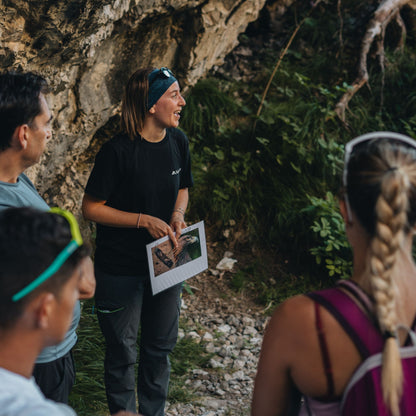 Professional mountain guide teaching hikers about local wildlife with photo guide during Friulian Dolomites wilderness trek